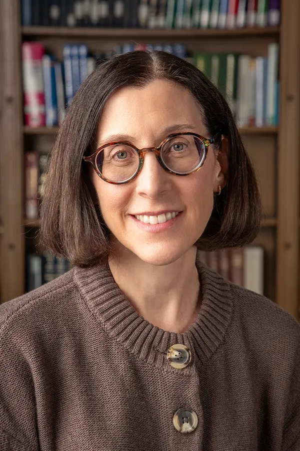 Photograph of Kristen Castellana, a white woman with dark brown hair and glasses.