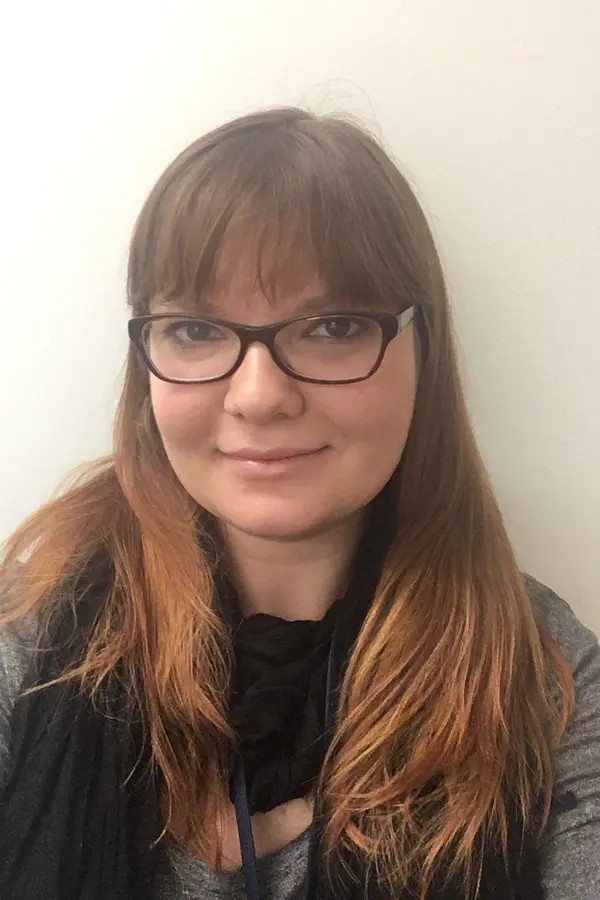 Photo of Kathryn Vanderboll, a white woman with long red hair and glasses.