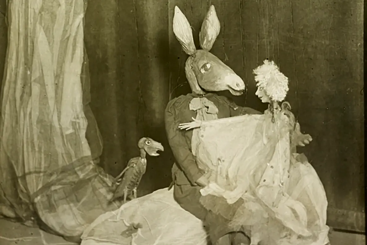 Puppets from Midsummers Night's Dream posed in a scene on stage