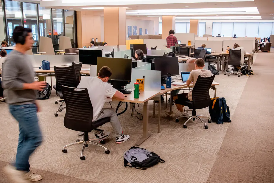 Open and deep space full of students working. 