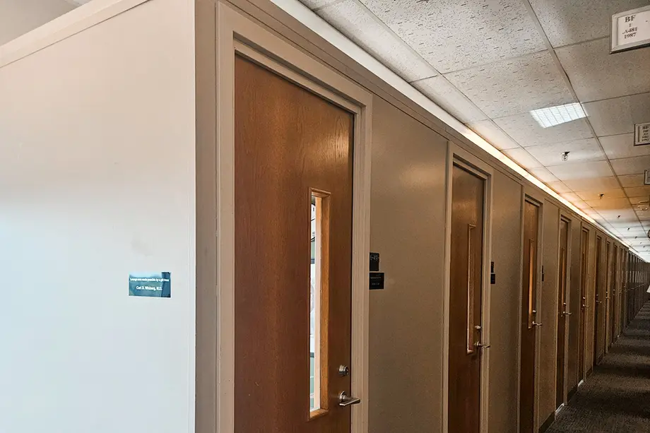Study carrels with doors, but the walls do not go to the ceiling.