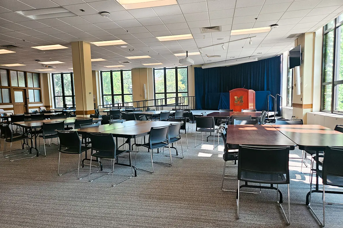 Gallery event space set up with tables and chairs and light streaming in.