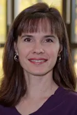 Doreen R Bradley's Photo.  A woman with dark brown hair and bangs, smiling and wearing a purple shirt.