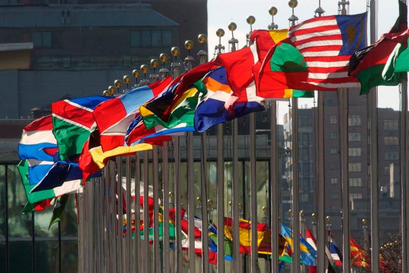 A line of flagpoles with flags representing United Nations members. 