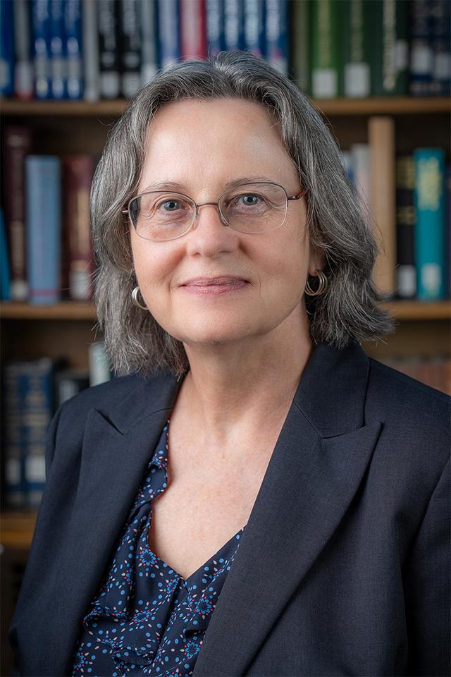 photo showing a white woman wearing a jacket and blouse