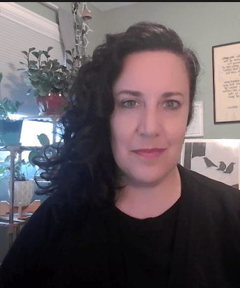 white woman with dark hair wearing a black sweater pictured in her home office