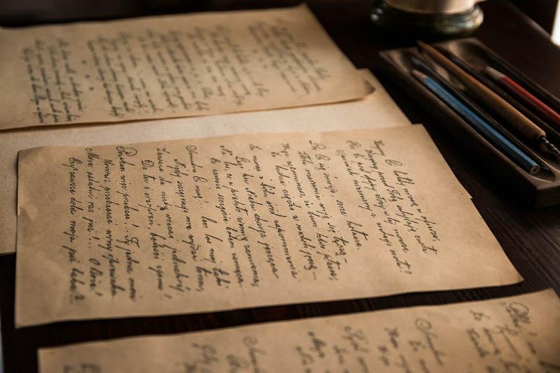 Several old letters, written in beautiful cursive, spread across a wooden table.