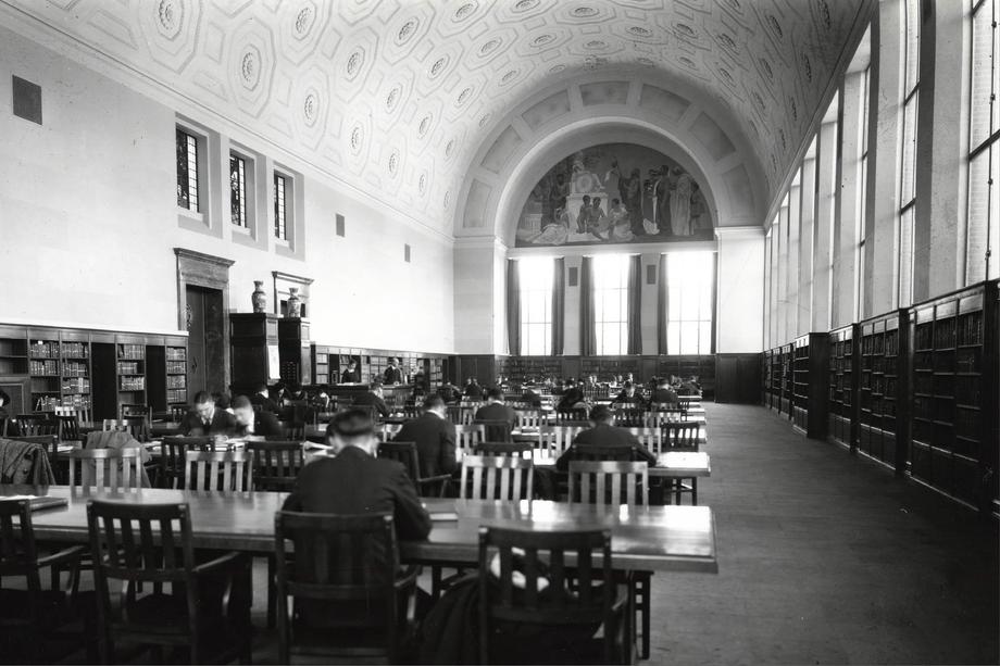 reading room with arched window and people seated at long tables