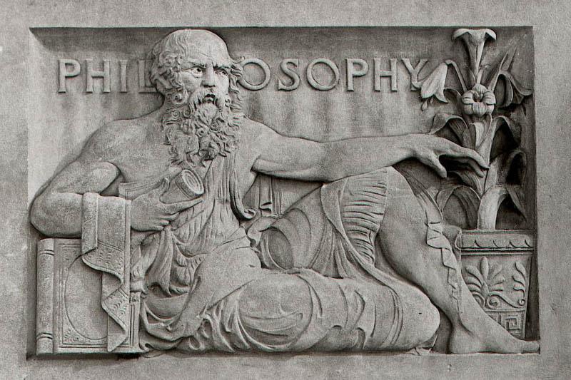 Sculpture on the front of a building with a philosopher sitting in a reclining position.