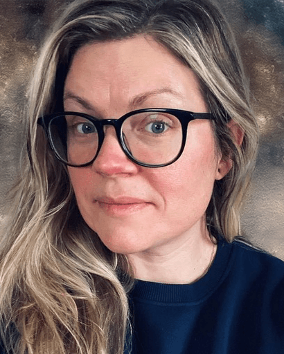 Self-portrait of Bridget Burke, a white person with brown and blonde hair and dark glasses