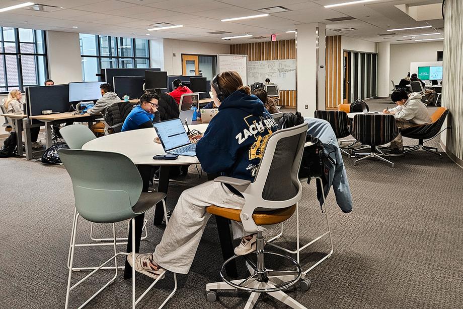 Students working at tables with extended display monitors