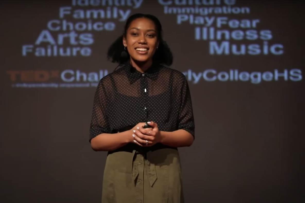 Black woman wearing a headset and talking into the camera.